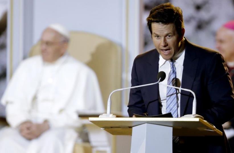 Pope Francis (L) listens to actor Mark Wahlberg speak at the Festival of Families in Philadelphia (photo credit: REUTERS)