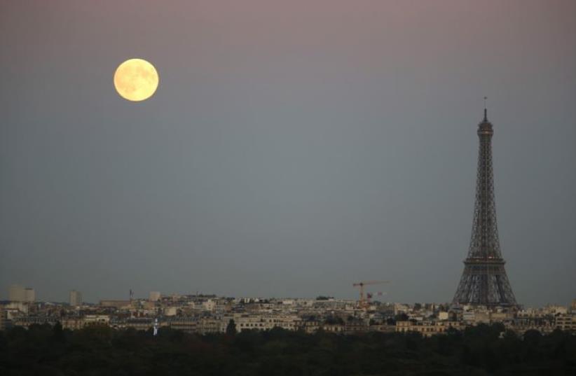 A super moon rises in the sky near the Eiffel tower as seen from Suresnes, Western Paris (photo credit: REUTERS)
