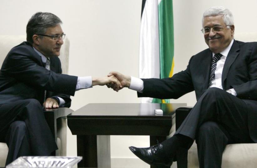 Palestinian Authority President Mahmoud Abbas (R) shakes hands with former justice minister Yossi Beilin (photo credit: REUTERS)
