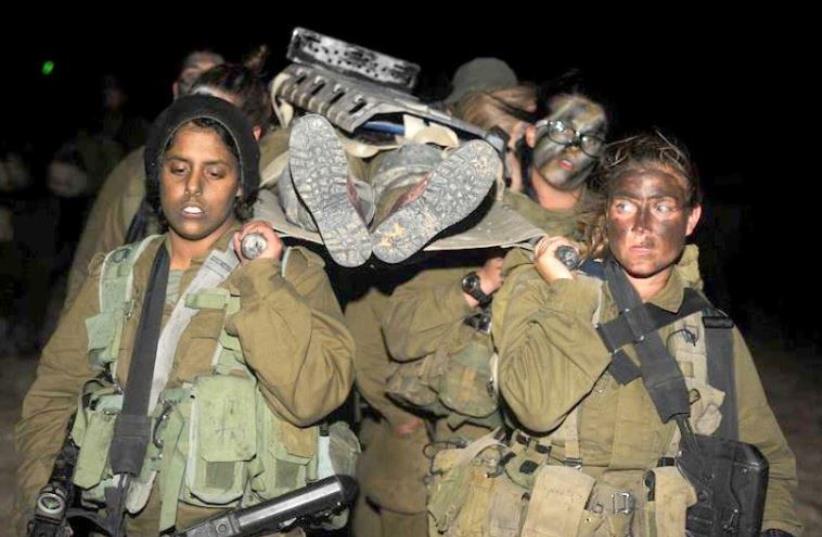 Female soldiers from the Caracal Battalion practice evacuating an injured soldier (photo credit: NOA CITY-ELIYAHU / BAMAHANE / ISRAEL DEFENSE FORCES)