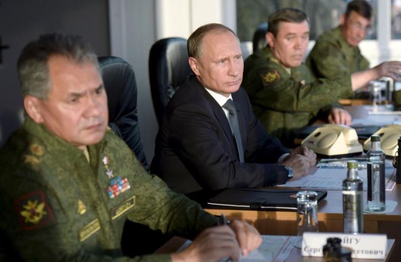 Russian President Vladimir Putin (C) with Defence Minister Sergei Shoigu (L) and armed forces Chief of Staff Valery Gerasimov observe troops during a training exercise  (photo credit: REUTERS)