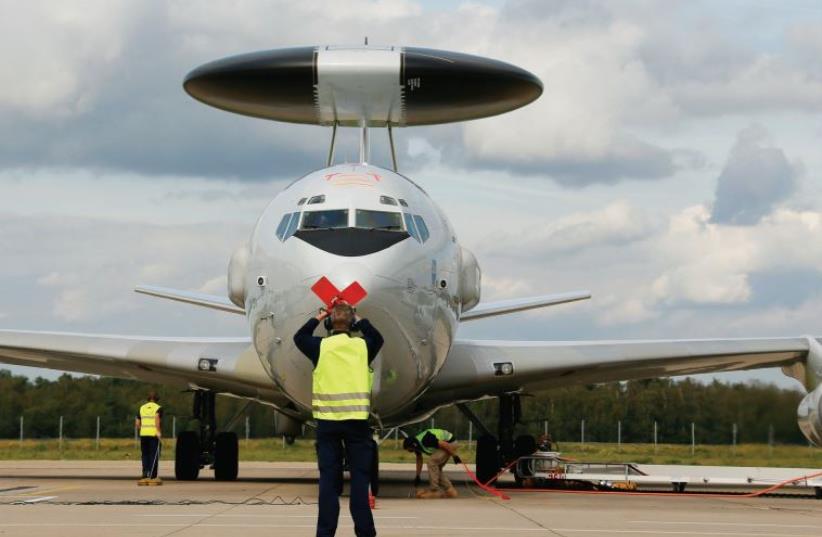A GROUND personnel member gives the sign to stop the engine to the captain of an AWACS aircraft. (photo credit: REUTERS)