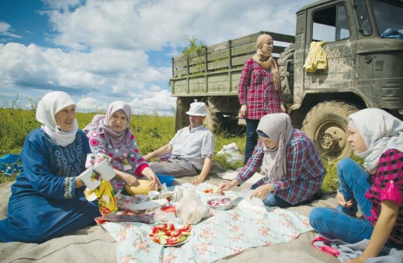 A family gathers for lunch while taking a break from farm duties (photo credit: ALBERT FISHMAN SADIKOV DISTRIBUTED BY ‘THE ARCHIVE’)