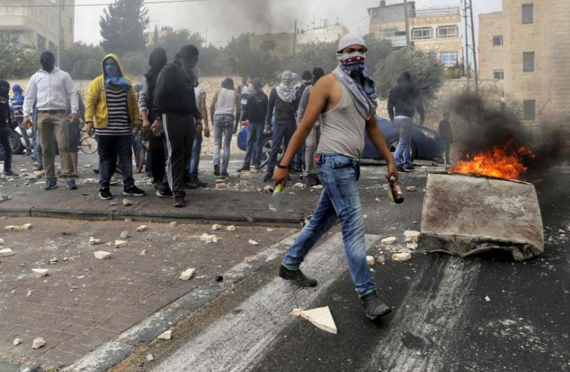 Stone-throwing Palestinians clash with Israeli police in Sur Baher, a village in the suburbs of east Jerusalem (photo credit: REUTERS)
