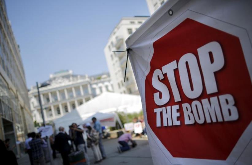 A sign which reads "Stop the Bomb" is seen as protesters gather outside the hotel where the Iran nuclear talks were being held in Vienna (photo credit: REUTERS)