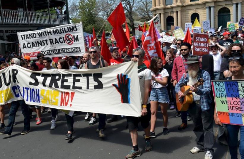Members of the left-wing coalition hold banners and placards as they march down a main street in the town of Bendigo, Australia, October 10, 2015 (photo credit: REUTERS)