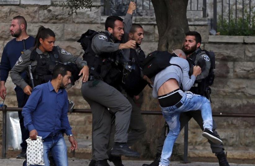 Border Police officers scuffle with a Palestinian protester as they detain him near Damascus Gate outside Jerusalem's Old City (photo credit: REUTERS)