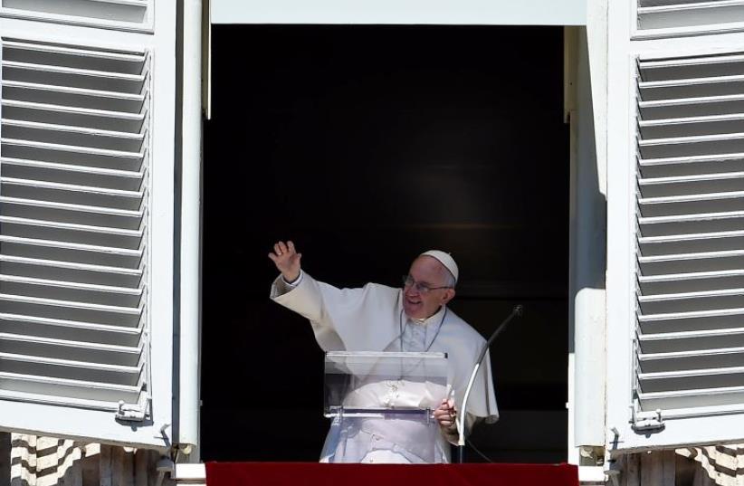 Pope Francis waves to pilgrims, gathered in St. Peter's square at Vatican, from the window of his appartment during his Sunday Angelus prayer on October 11, 2015. (photo credit: AFP PHOTO / VINCENZO PINTO)