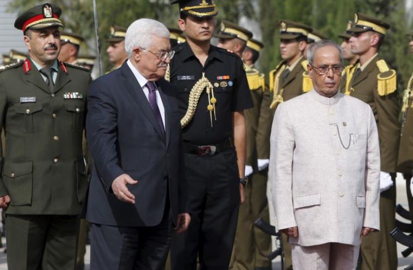 Palestinian President Mahmoud Abbas (2nd L) and Indian President Pranab Mukherjee (R) review the honor guard upon Mukherjee's arrival at the West Bank city of Ramallah (photo credit: REUTERS)