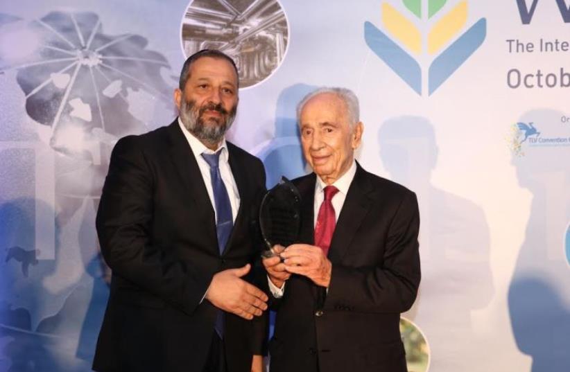Shimon Peres (R) receiving a Lifetime Achievement Award from Economy Minister Arye Deri at WATEC Israel 2015 (photo credit: Courtesy)