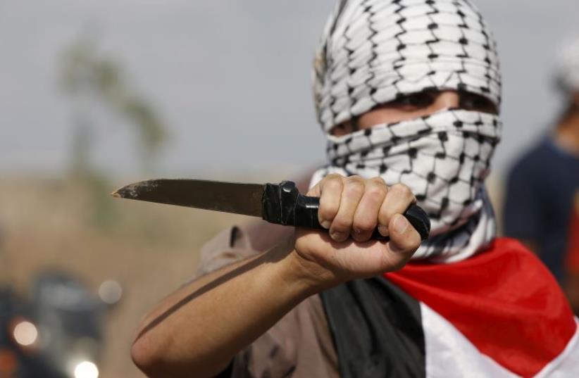 A Palestinian holding a knife in Hebron (photo credit: REUTERS)