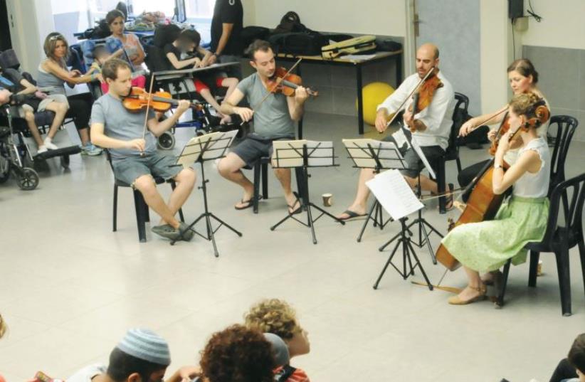 Musethica performers play for a group of disabled children as part of their activities (photo credit: COURTESY MUSETHICA)