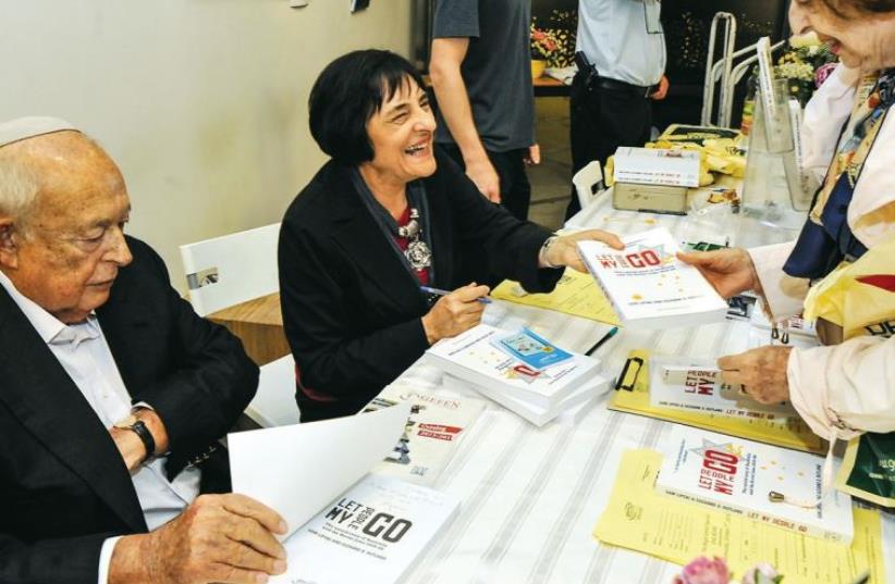 Isi Liebler and Suzanne Rutland sign copies of their books at a launch party in Jerusalem earlier this month (photo credit: ANDRES LACKO)