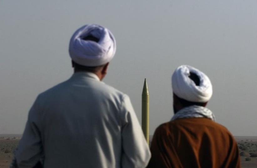 Iranian clerics look at a ballistic missile Shahab 1 before being launched during the second day of military exercises (photo credit: AFP PHOTO)
