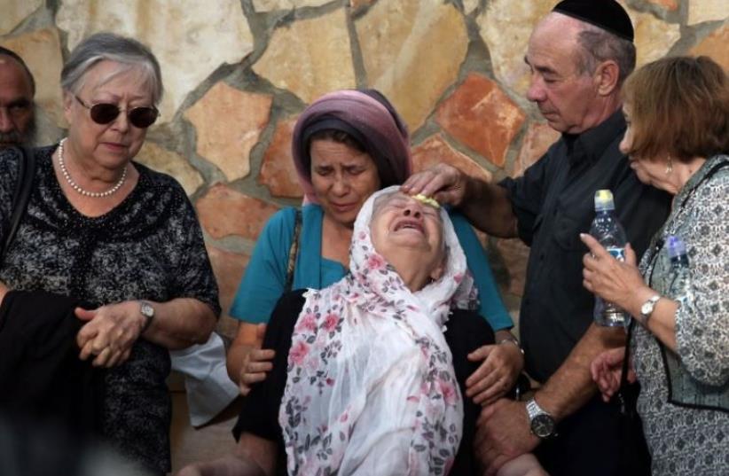 The mother of 51-year-old Israeli Alon Guverg, who was killed a day earlier when Palestinian attackers shot at a bus, mourns during his funeral procession in Jerusalem (photo credit: AFP PHOTO)