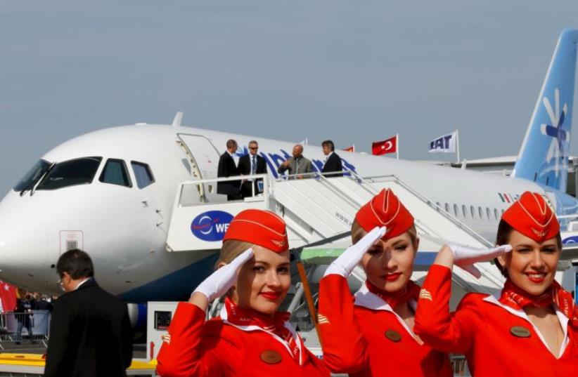 Cabin crew members of Russian carrier Aeroflot pose in front of a Sukhoi Superjet 100 airplane during a photo session at the 51st Paris Air Show at Le Bourget airport near Paris (photo credit: REUTERS)