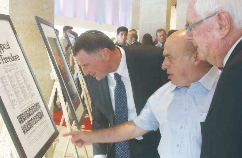 KNESSET SPEAKER Yuli Edelstein looks at 50 historic photographs from the Soviet Jewish exodus exhibited by Limmud FSU and ‘The Jerusalem Post’ at a special ceremony marking 25 years since ‘the opening of the gates’ in the Knesset’s Chagall Hall yesterday. (photo credit: MARC ISRAEL SELLEM)
