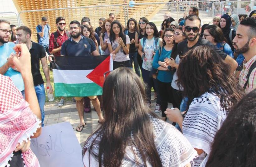 PRO-ARAB PROTESTERS display a Palestinian flag at the entrance to Tel Aviv University yesterday. (photo credit: IM TIRTZU)