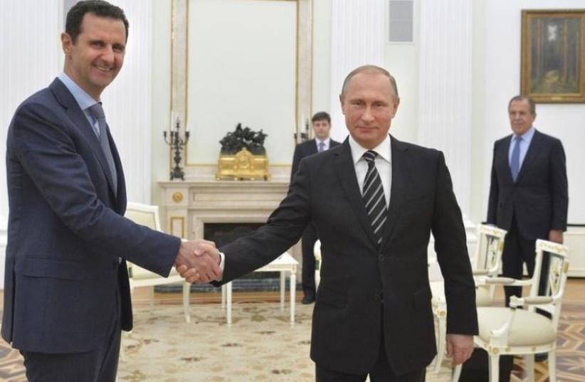 Russian President Vladimir Putin (R) shakes hands with Syrian President Bashar Assad at the Kremlin in Moscow, Russia, October 20, 2015 (photo credit: REUTERS)