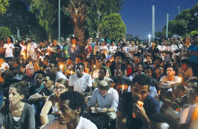 MOURNERS HOLD a candle-light vigil for Eritrean Haptom Zarhum in Tel Aviv’s Levinsky Park last night.  (photo credit: BEN HARTMAN)