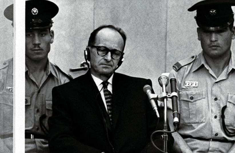 Israeli police flank Adolf Eichmann, the Nazi SS colonel who headed the Gestapo's Jewish Section and was responsible for millions of Jews' deaths in Nazi concentration camps, as he stands trial inside a bulletproof booth in a Jerusalem court (photo credit: REUTERS)