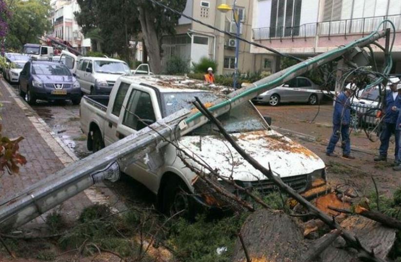 Storm downs electrical pole on a car in central Israel (photo credit: ISRAEL ELECTRIC CORPORATION‏ FACEBOOK)