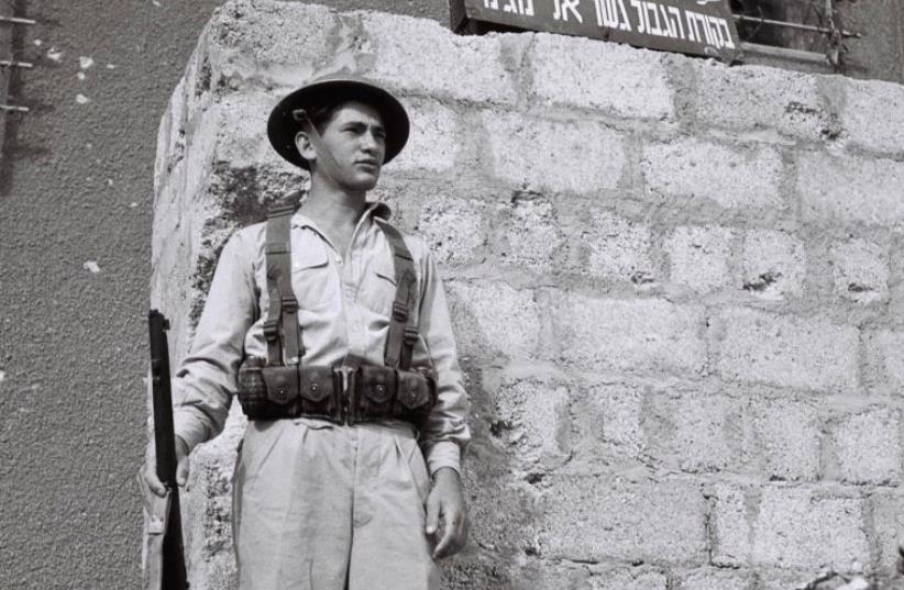 A JEWISH solider stands guard outside a building days after the British Mandate ended in 1948 (photo credit: REUTERS)