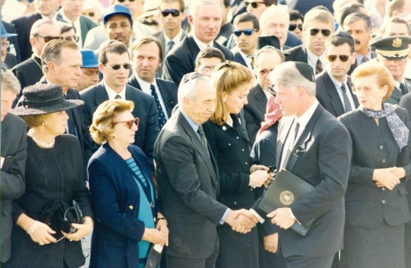 US President Bill Clinton shakes the hand of acting prime minister Shimon Peres following his eulogy (photo credit: JERUSALEM POST ARCHIVE)