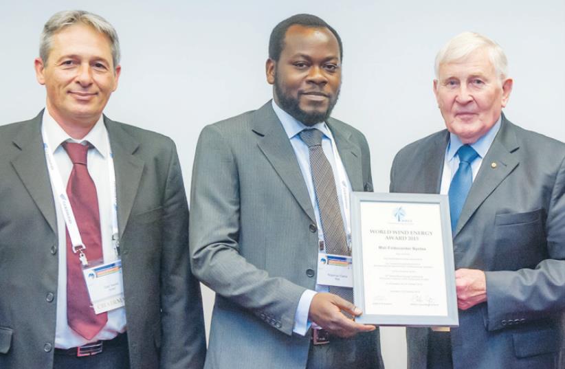 THE WORLD WIND ENERGY AWARD 2015 is presented to Mali-Folkecenter Nyetaa representative Nopenyo Dabla (second left) by WWEA president Peter Rae at the World Wind Energy Conference in Jerusalem yesterday. Also pictured are WWEA vice president and Israel WEA chairman Gadi Hareli (left) and WWEA secret (photo credit: CHEN DAMARI)