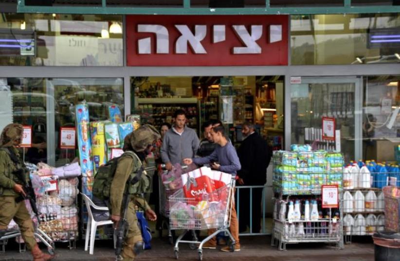 Soldiers patrolling the parking lot by the Rami Levi supermarket in the Gush Etzion commercial center.  (photo credit: TOVAH LAZAROFF)