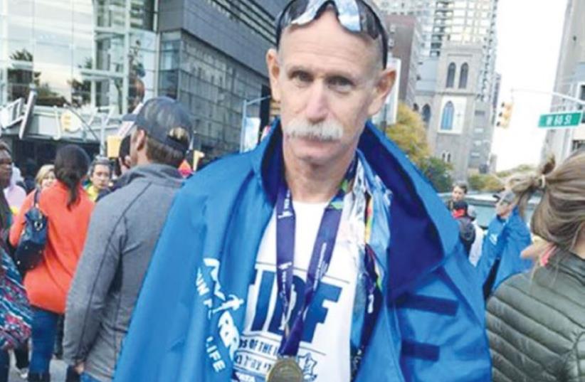DISABLED IDF veteran Adi Deutsch shows off his medal at Manhattan’s Columbus Circle after running in the New York City Marathon on Sunday (photo credit: Courtesy)