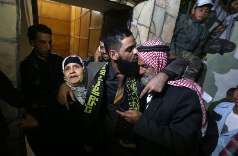 Former Palestinian detainee Mohammed Allan hugs his father and mother at their house in Nablus (photo credit: JAAFAR ASHTIYEH / AFP)