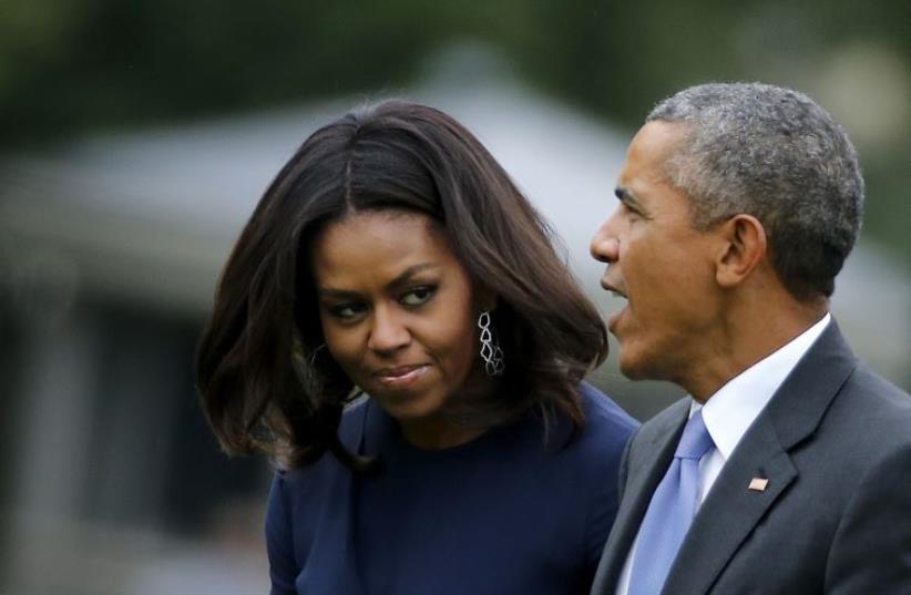 US President Barack Obama (R) and first lady Michelle Obama arrive from New York to the South Lawn of the White House in Washington (photo credit: REUTERS)