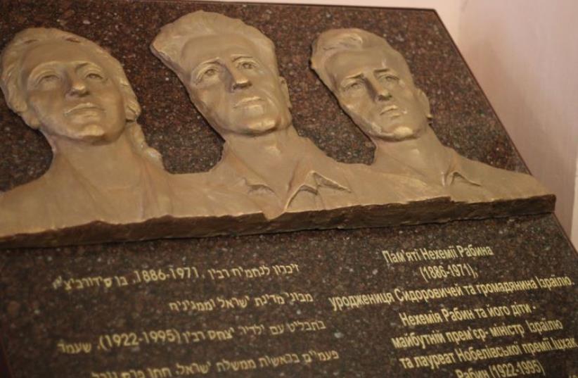 A memorial tablet carrying the bronze image of Nechemia Rabin flanked by his two children, Yitzhak and Rachel (photo credit: Courtesy)