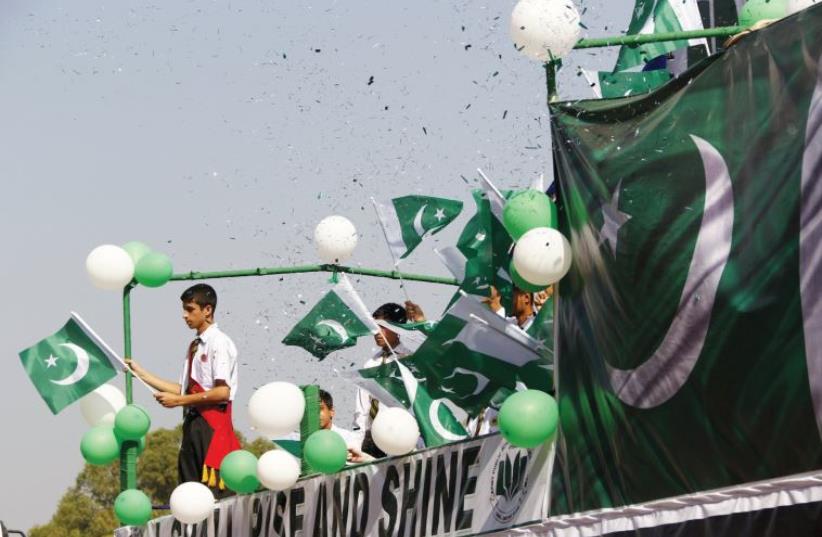 PEOPLE WAVE Pakistani flags at a rally earlier this year. (photo credit: REUTERS)