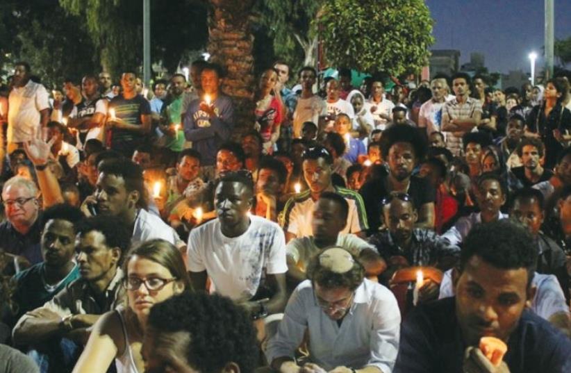 Mourners hold a candlelit vigil for Eritrean Haptom Zarhum in Tel Aviv’s Levinsky Park on October 21 (photo credit: BEN HARTMAN)