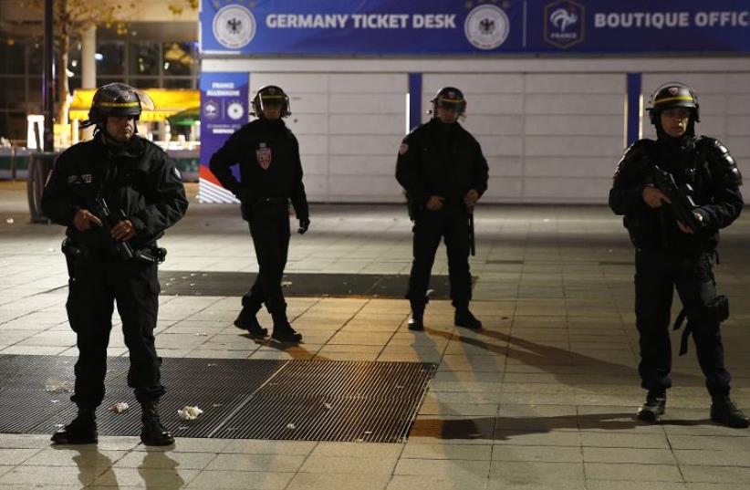 Police stand outside the Stade de France where explosions were reported to have detonated outside the stadium during the France vs German friendly soccer match near Paris, November 13, 2015 (photo credit: REUTERS)