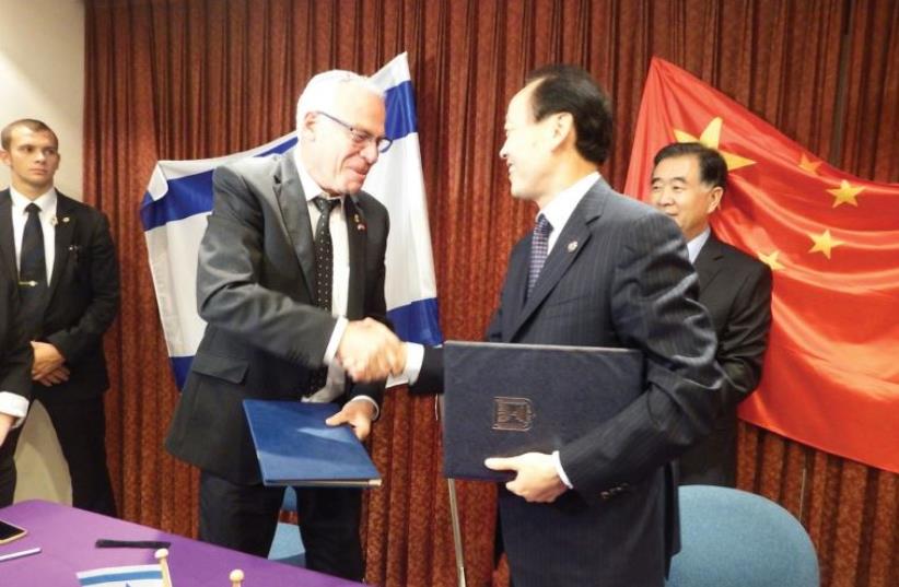 AGRICULTURE MINISTER Uri Ariel and Chinese Deputy Agriculture Minister Yu Xinrong shake hands after signing an agricultural development plan on Thursday. (photo credit: NAAMA ROSENBERG)