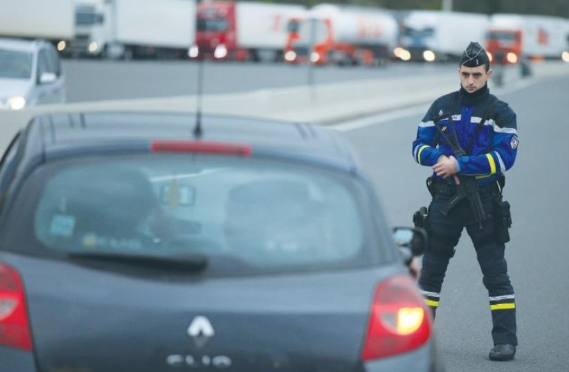A FRENCH GENDARME stands along the road as he checks vehicles and verifies the identity of travelers on the A1 motorway (photo credit: REUTERS)