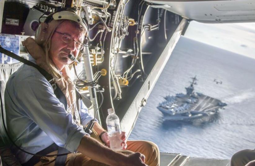 The USS Theodore Roosevelt can be seen in the background as US Secretary of Defense Ash Carter flies in a V-22 Osprey (photo credit: REUTERS)