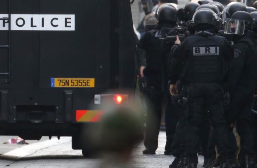 Members of French special police forces of the Research and Intervention Brigade (BRI) are seen near a raid zone in Saint-Denis, near Paris, France, November 18, 2015  (photo credit: REUTERS)