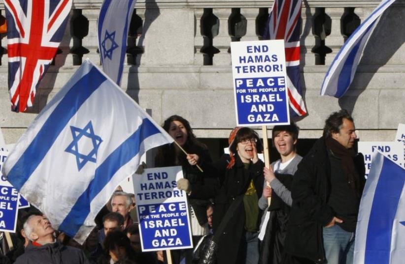Pro-Israel demonstrators wave banners during a rally in London (photo credit: REUTERS/ANDREW PARSONS)