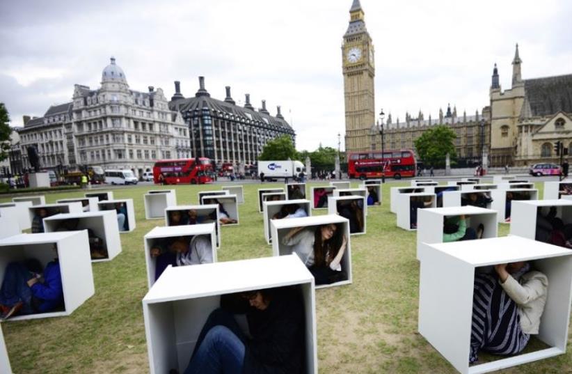 Demonstrators crammed into boxes at London’s Parliament Square last year, purporting to represent living conditions in Gaza, during an event organized by Oxfam (photo credit: REUTERS)