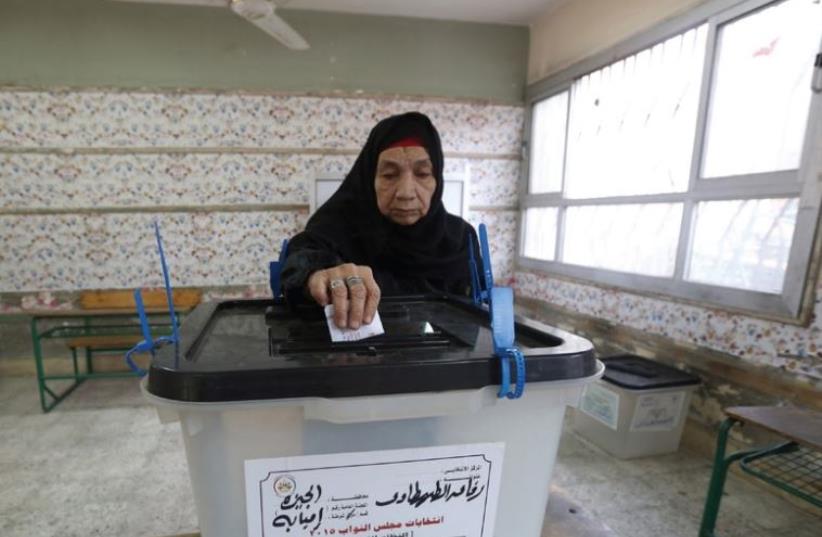 A woman casts her vote at a polling station during the runoff to the first round of parliamentary elections in Imbaba, Egypt, October 27 (photo credit: REUTERS)