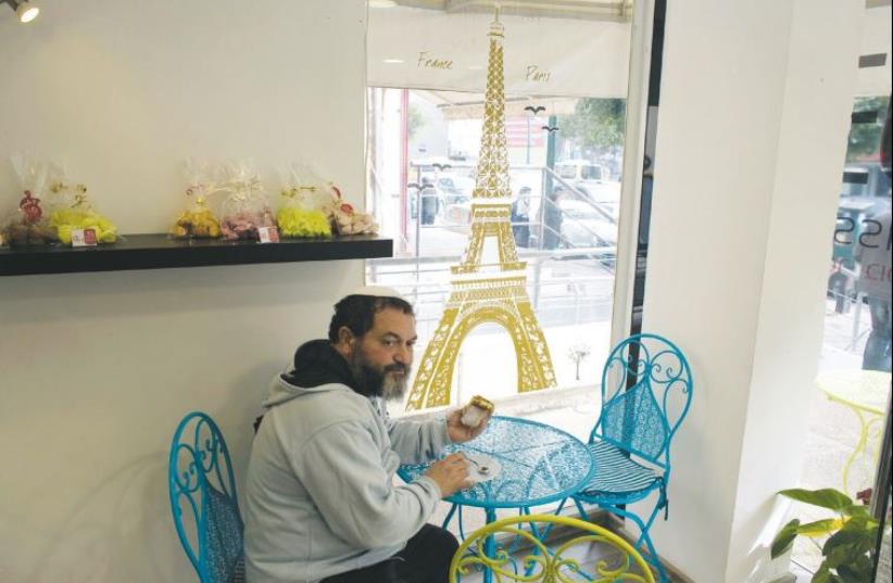 A member of the French community in Israel sits in a patisserie in Netanya, on January 25 (photo credit: RONEN ZVULUN / REUTERS)