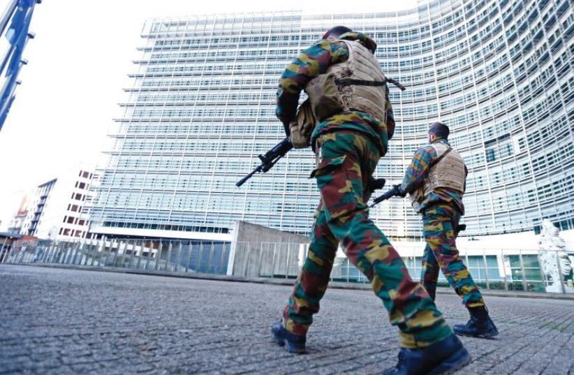 BELGIAN SOLDIERS patrol outside European Commission headquarters in Brussels as police searched the area following the Paris terror attacks in mid-November that claimed the lives of 130 people (photo credit: REUTERS)
