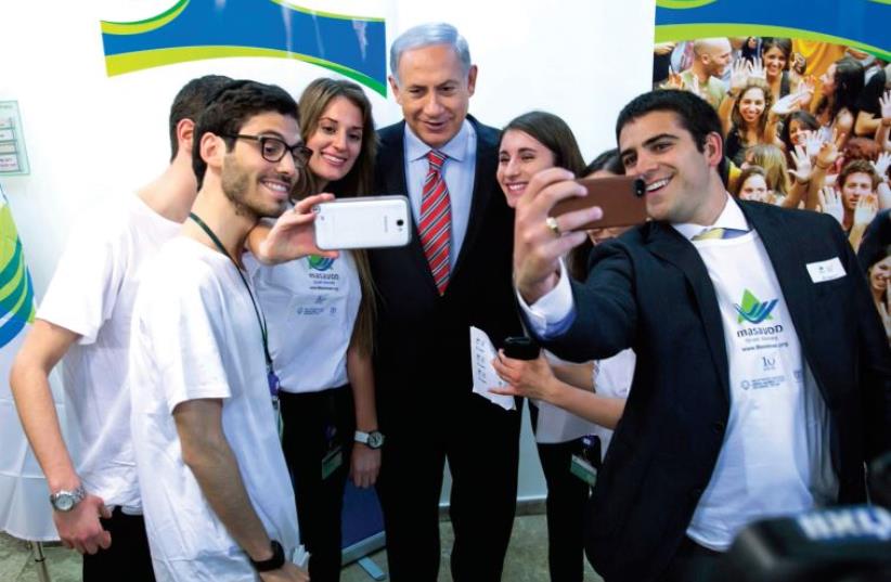 Benjamin Netanyahu takes a selfie with Masa participants (photo credit: REUTERS)