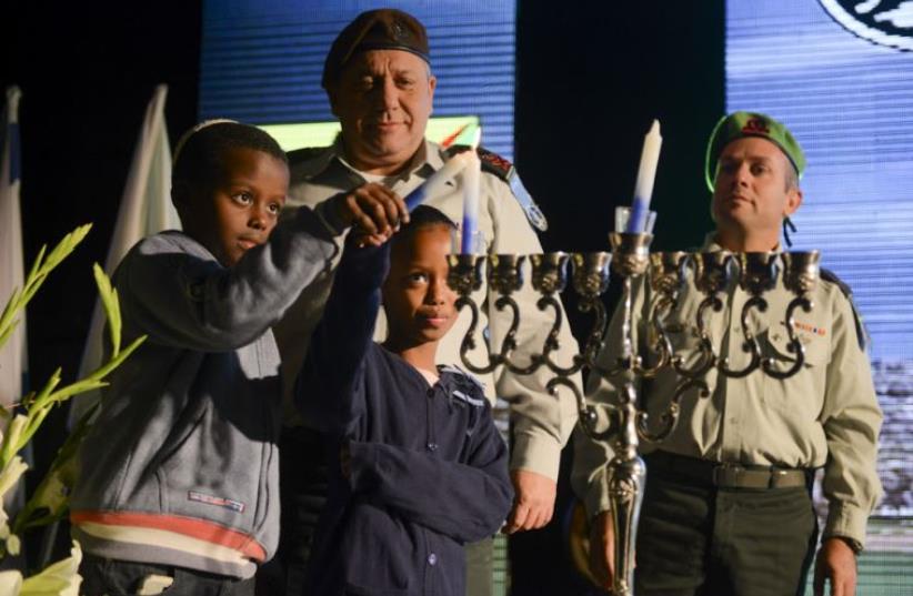 Eisenkot watching as children light the first Hanukah candle at the headquarters of the Gaza Division on Sunday night (photo credit: IDF SPOKESMAN’S UNIT)
