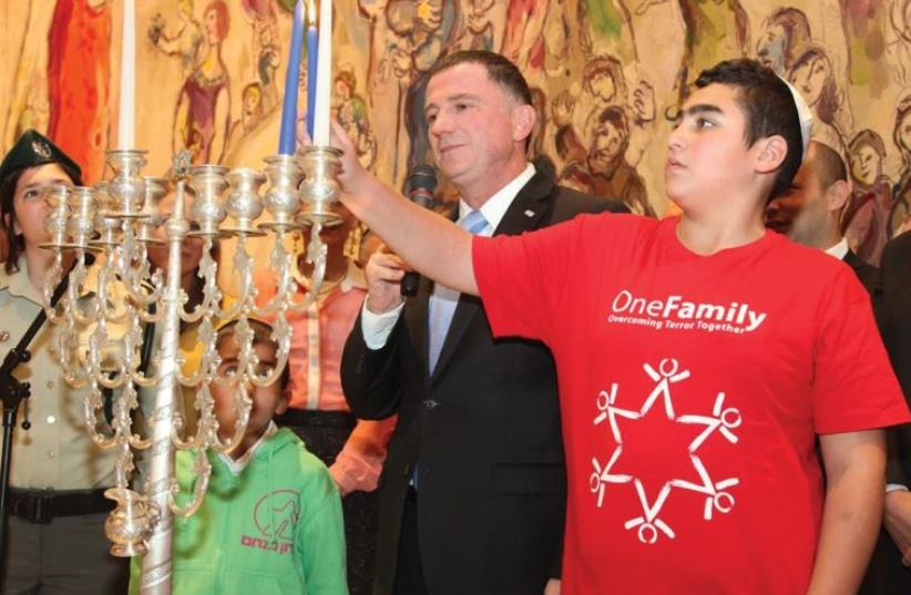 KNESSET SPEAKER Yuli Edelstein lights Hanukka candles with children who are terrorism victims, children with cancer and Border Police officers at the Knesset (photo credit: KNESSET)