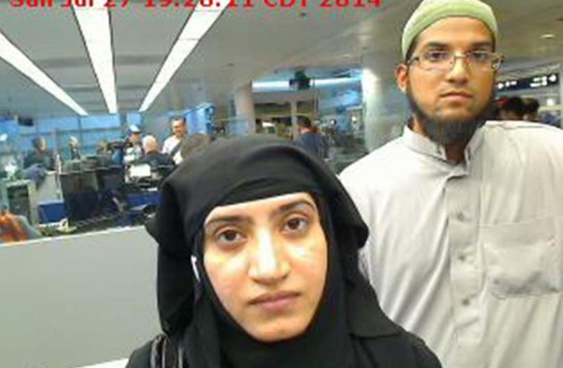 Tashfeen Malik, (L), and Syed Farook are pictured passing through Chicago's O'Hare International Airport in this July 27, 2014 handout photo obtained by Reuters (photo credit: REUTERS)